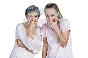 Mother and daughter laughing with hand on mouth