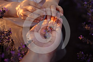 Mother and daughter in a lavender field. Hands hold purple flowers. Love, happiness, pleasure, tranquility, unity with