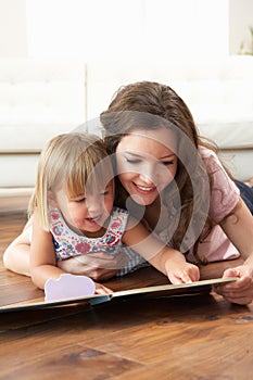 Mother And Daughter Learning To Read At Home