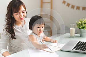 Mother and daughter are learning to write.