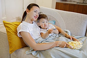 Mother Daughter Leisure. Smiling Woman And Toddler Female Child Watching Tv Together