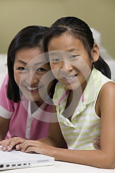 Mother and Daughter in living room Using Laptop Together portrait