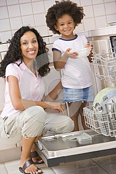 Mother And Daughter Loading Dishwasher