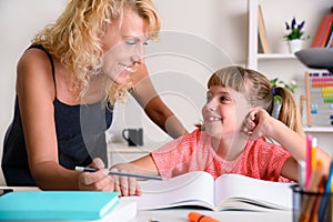 Mother and daughter looking with complicity in school studies home