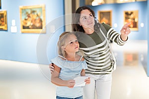 Mother and daughter looking at expositions in museum