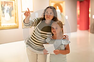 Mother and daughter looking at expositions in museum