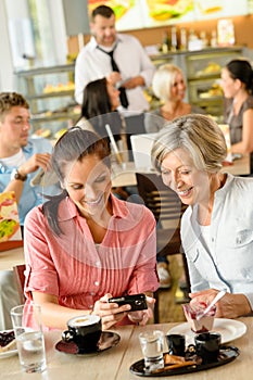 Mother and daughter looking at pictures cafe