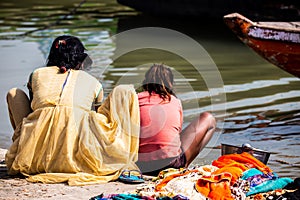 Mother and daughter of low caste washing their clothes in the Ganges river, in Varanasi, India