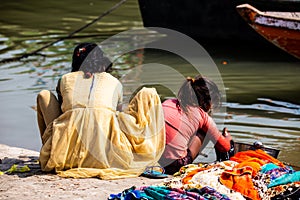 Mother and daughter of low caste washing their clothes in the Ganges river, in Varanasi, India