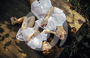 Mother and daughter lying on old bench in the forest during the outing