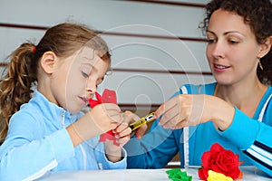 Mother and daughter make artificial roses photo