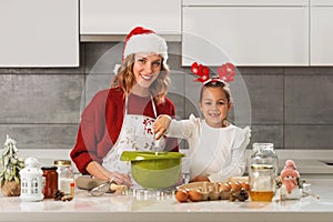 Mother and daughter making Christmas cookies in the kitchen