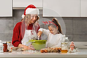 Mother and daughter making Christmas cookies in the kitchen