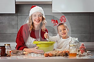 Mother and daughter making Christmas cookies in the kitchen