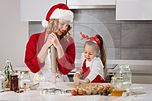 Mother and daughter making Christmas cookies in the kitchen