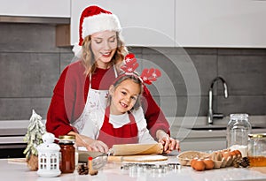 Mother and daughter making Christmas cookies in the kitchen
