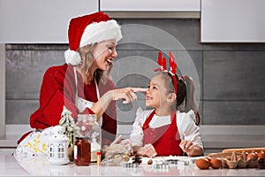 Mother and daughter making Christmas cookies in the kitchen