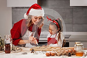 Mother and daughter making Christmas cookies in the kitchen