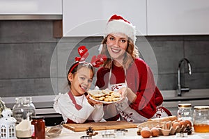 Mother and daughter making Christmas cookies in the kitchen