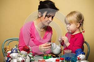 Mother and daughter making Christmas decorations