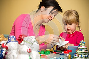 Mother and daughter making Christmas decorations