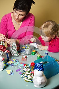 Mother and daughter making Christmas decorations