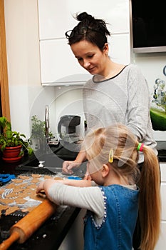 Mother and daughter making gingerbread cookies at home