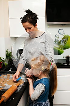 Mother and daughter making gingerbread cookies at home
