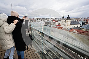 Mother with daughter making photo from panorama view of city