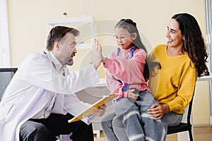 Mother with daughter meeting pediatrician doctor at the clinic for health check talking about mental problems