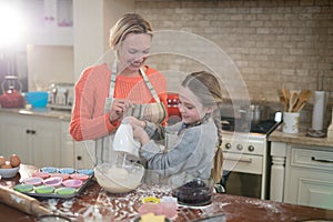 Mother and daughter mixing eggs and wheat flour in a bowl