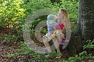 Mother and daughter moment inside the forest. Smilling and having a good time. Nature education