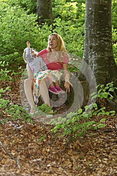 Mother and daughter moment inside the forest. Smilling and having a good time. Nature education