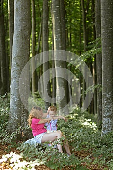 Mother and daughter moment inside the forest. Smilling and having a good time. Nature education