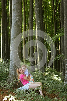 Mother and daughter moment inside the forest. Smilling and having a good time. Nature education