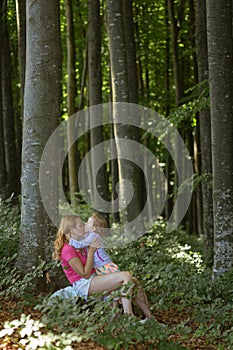 Mother and daughter moment inside the forest. Smilling and having a good time. Nature education