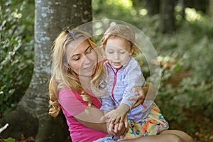 Mother and daughter moment inside the forest. Smilling and having a good time. Nature education