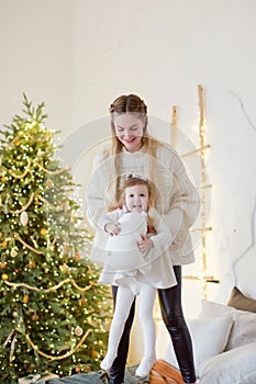 Mother and daughter near Christmas tree