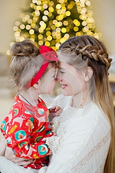 Mother and daughter near Christmas tree