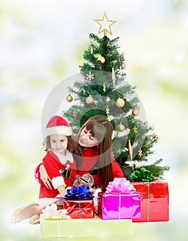 Mother with daughter near the Christmas tree