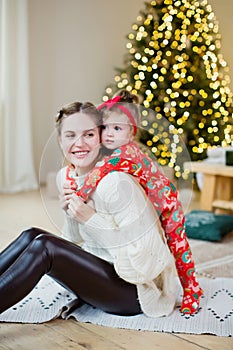 Mother and daughter near Christmas tree