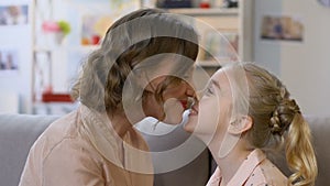 Mother and daughter nuzzling, playing games, having fun together, closeup