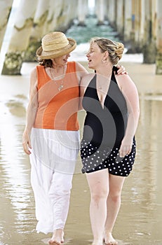 Mother & daughter outdoors seaside enjoying summer time & relaxing together