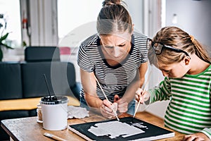 Mother and daughter painting canvas