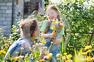 Mother and daughter picking pretty colourful flowes in their organic garden photo