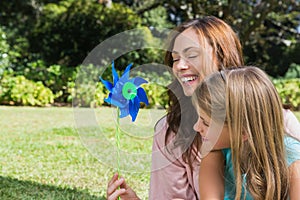 Mother with daughter with a pinwheel in the park