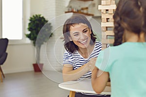 Mother and daughter play board games at home. Happy family.