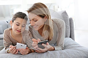 Mother and daughter playing games on smartphone