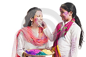 Mother and daughter playing holi.