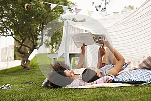 Mother And Daughter Playing In Home Made Garden Den